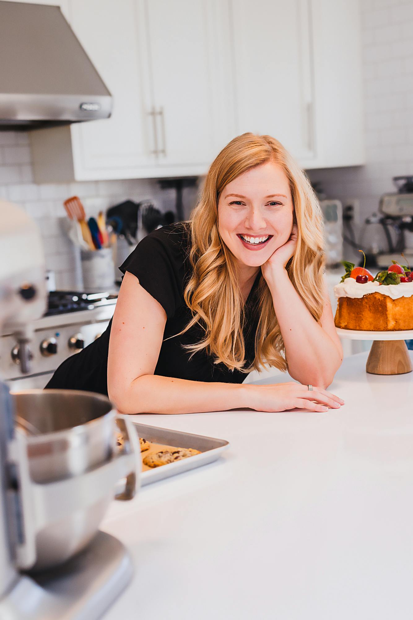 Leslie leaning on a kitchen island in a black shirt