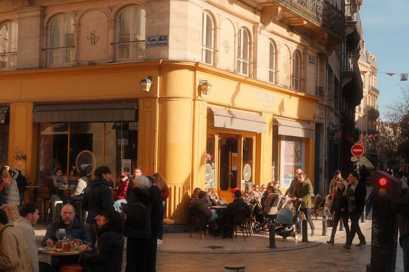 People sitting at outdoor cafe on sunny day.