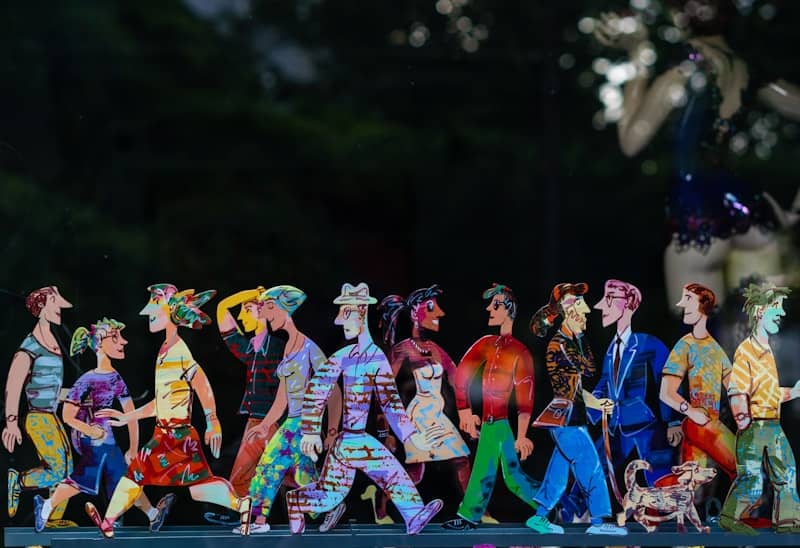Colorful wooden figures depicting people walking in a line.