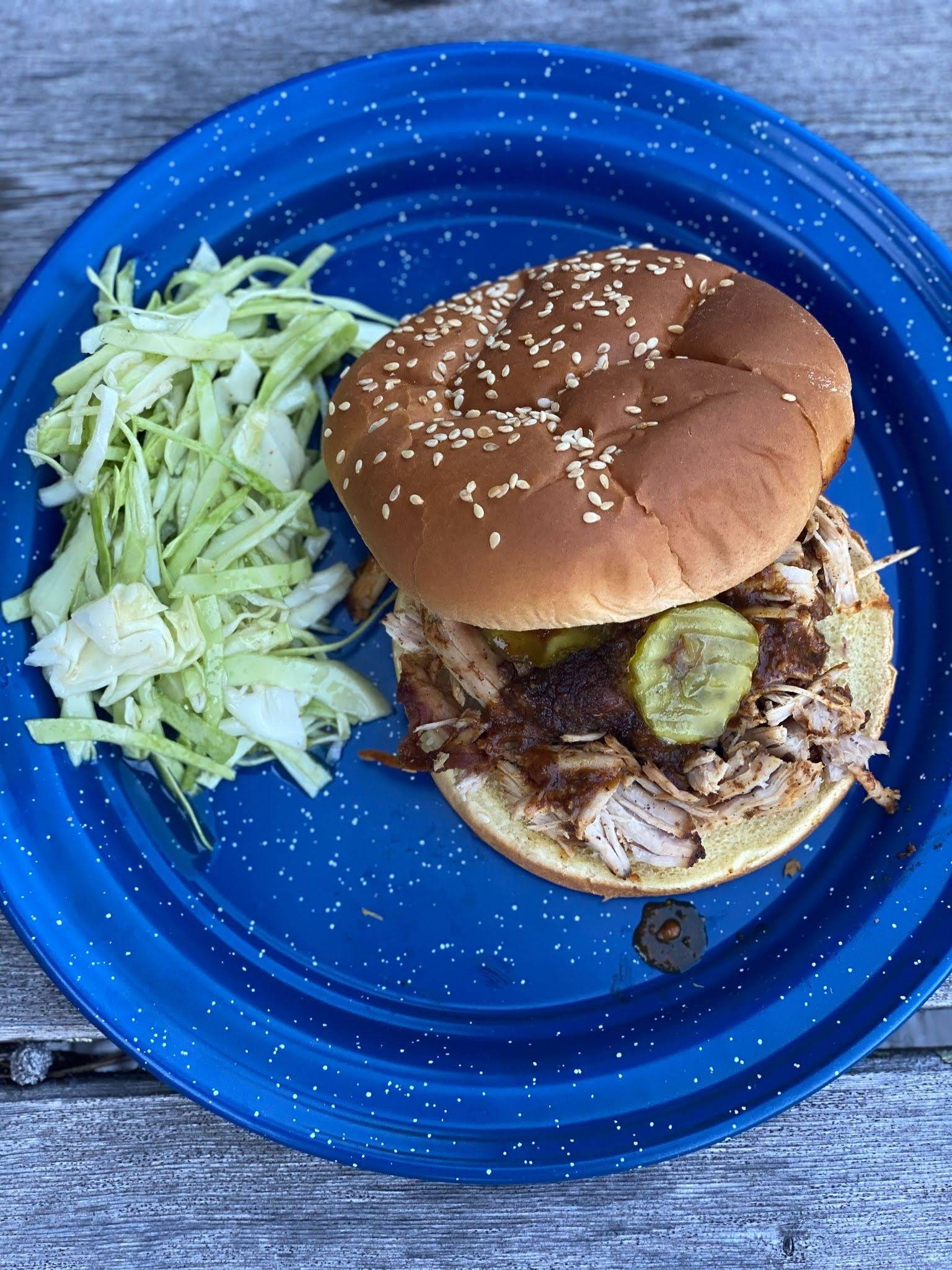 Pulled pork sandwich with slatherin' sauce and pickles.