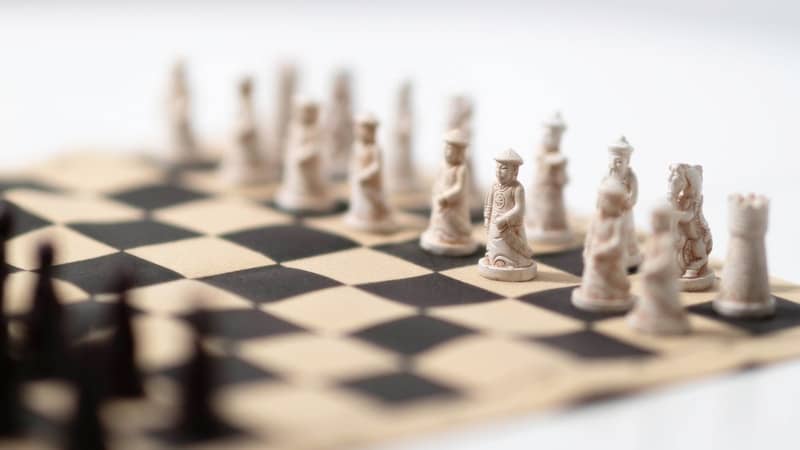 A black and white chess board with pieces on it