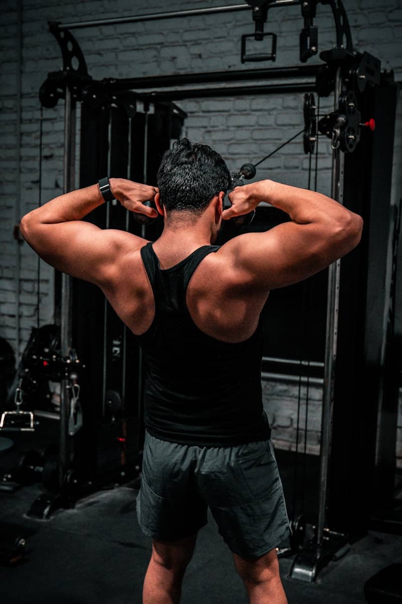 Man working out at a gym, back turned.
