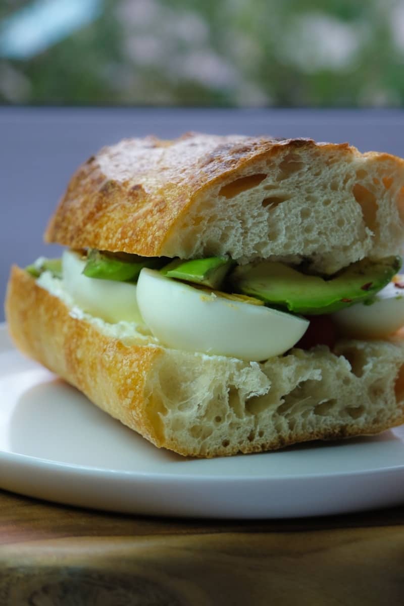 A sandwich with egg and avocado on a plate