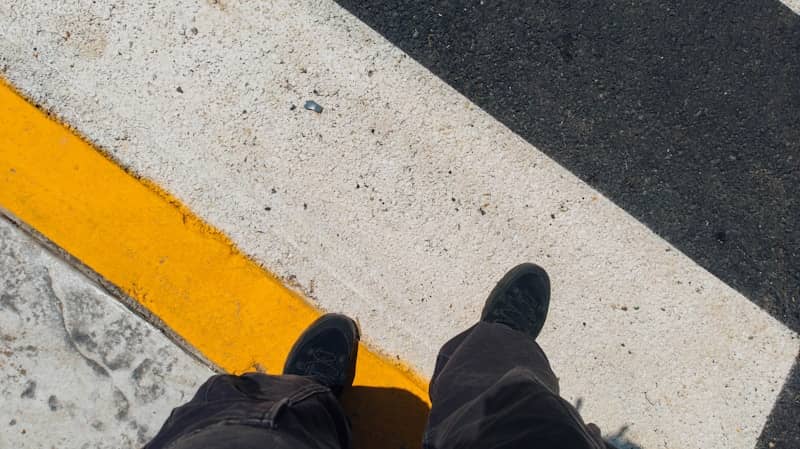 Person's legs and feet on a crosswalk