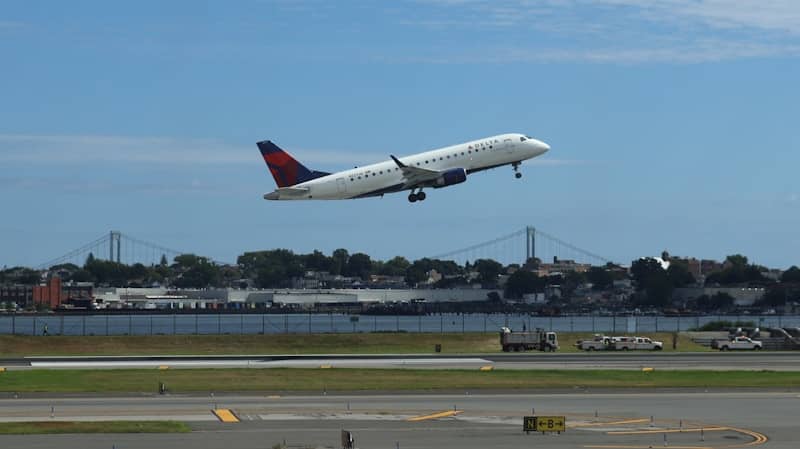 Airplane taking off with a city skyline background.