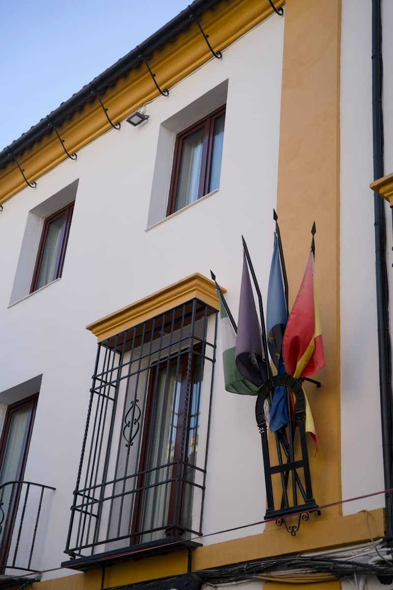 Building facade with colorful flags and windows.