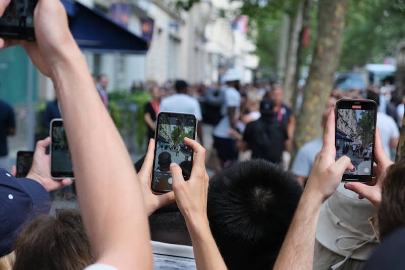 A group of people holding up their cell phones