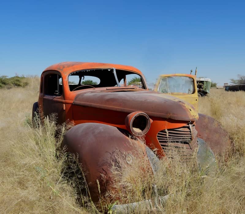 An old rusted out truck sitting in a field