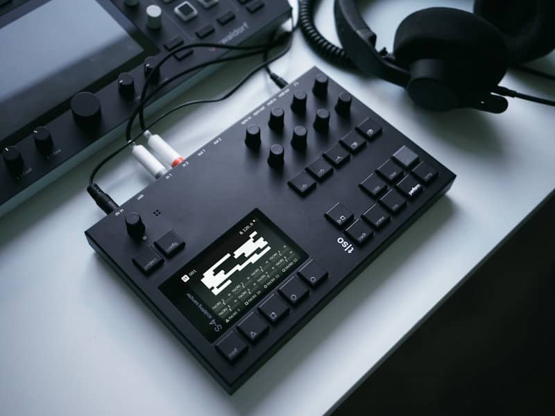 Black music production equipment with headphones on desk