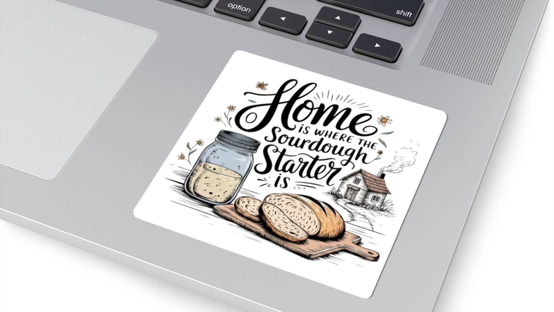 "Home is where the sourdough starter is" which kiss cut sticker on a gray computer