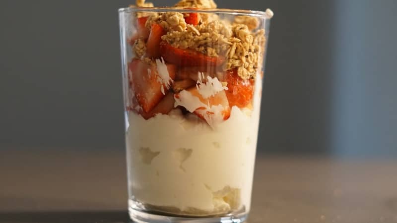 A layered parfait with yogurt, strawberries, and granola.
