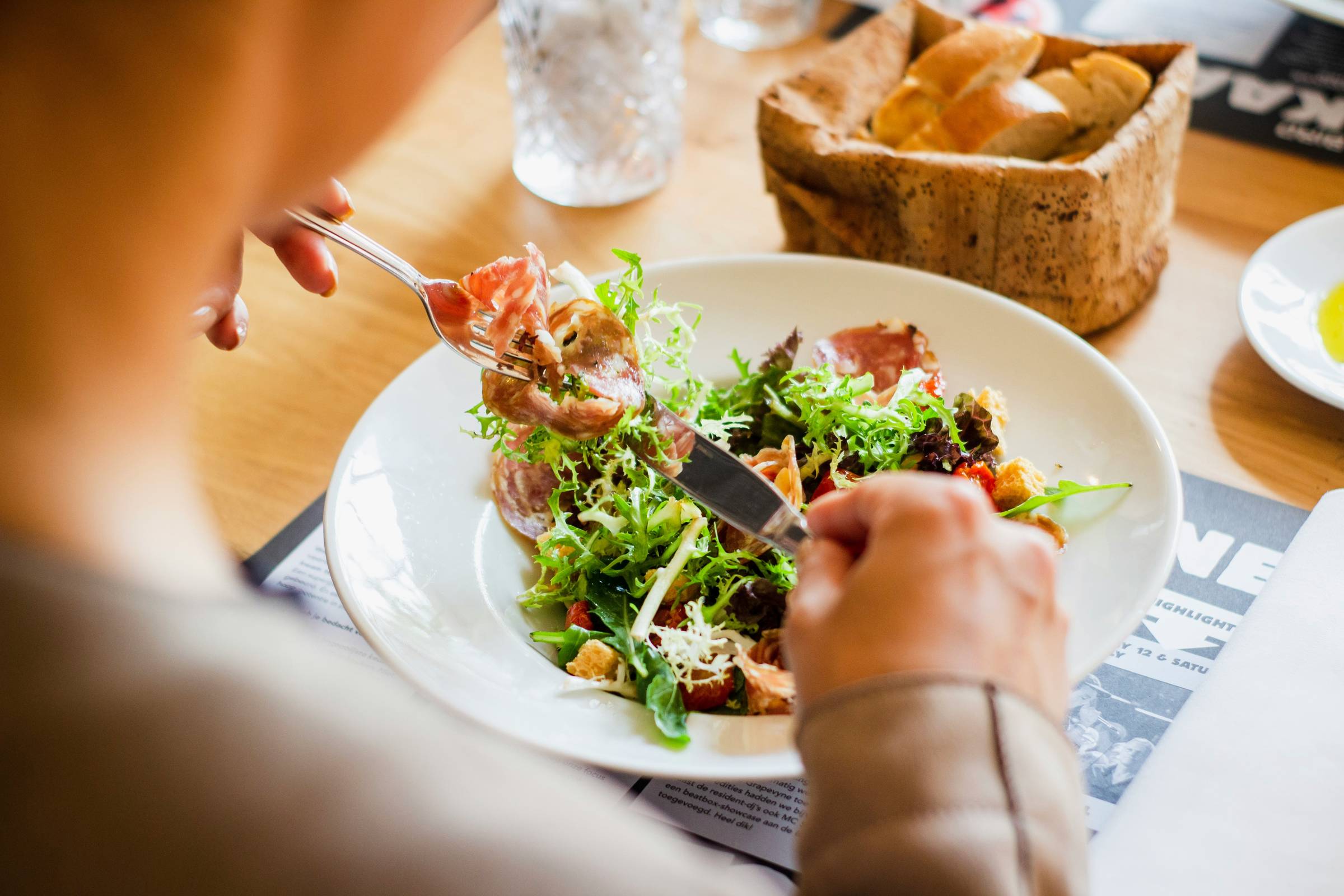 Woman eating salad, Photo by Louis Hansel on Unsplash