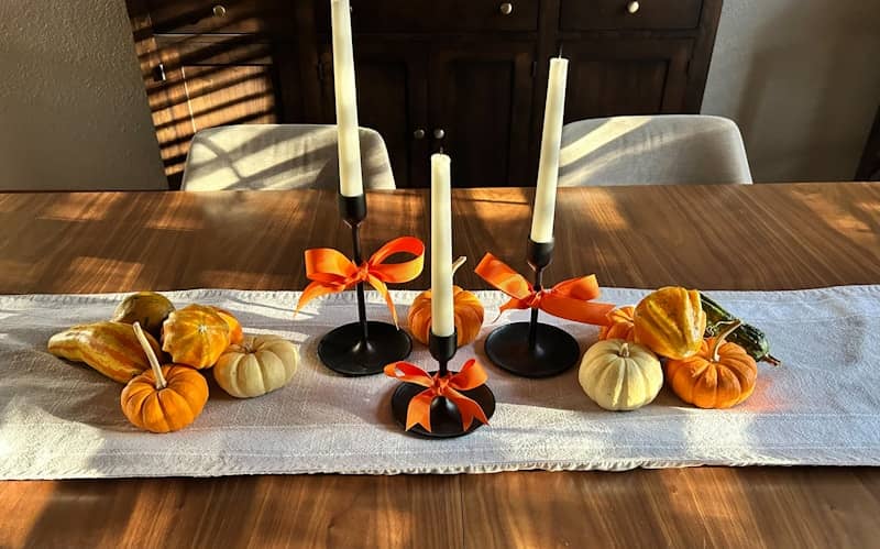 Mindful eating at a table with candlesticks with pumpkins and gourds.