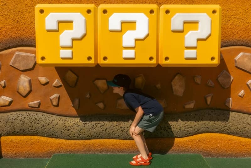 Child looking at three question mark blocks
