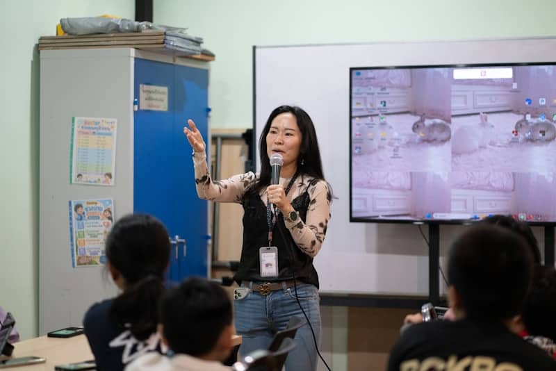 A woman presents to an audience with a microphone.