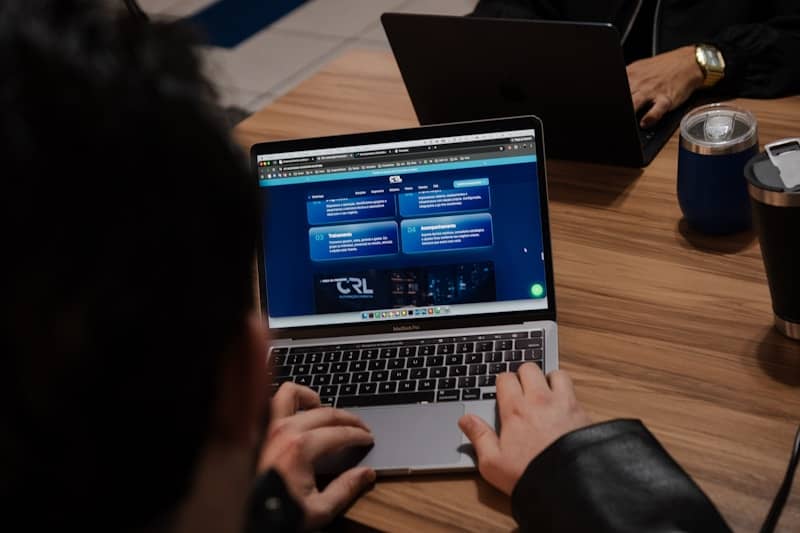 Hands typing on a laptop displaying a web interface.