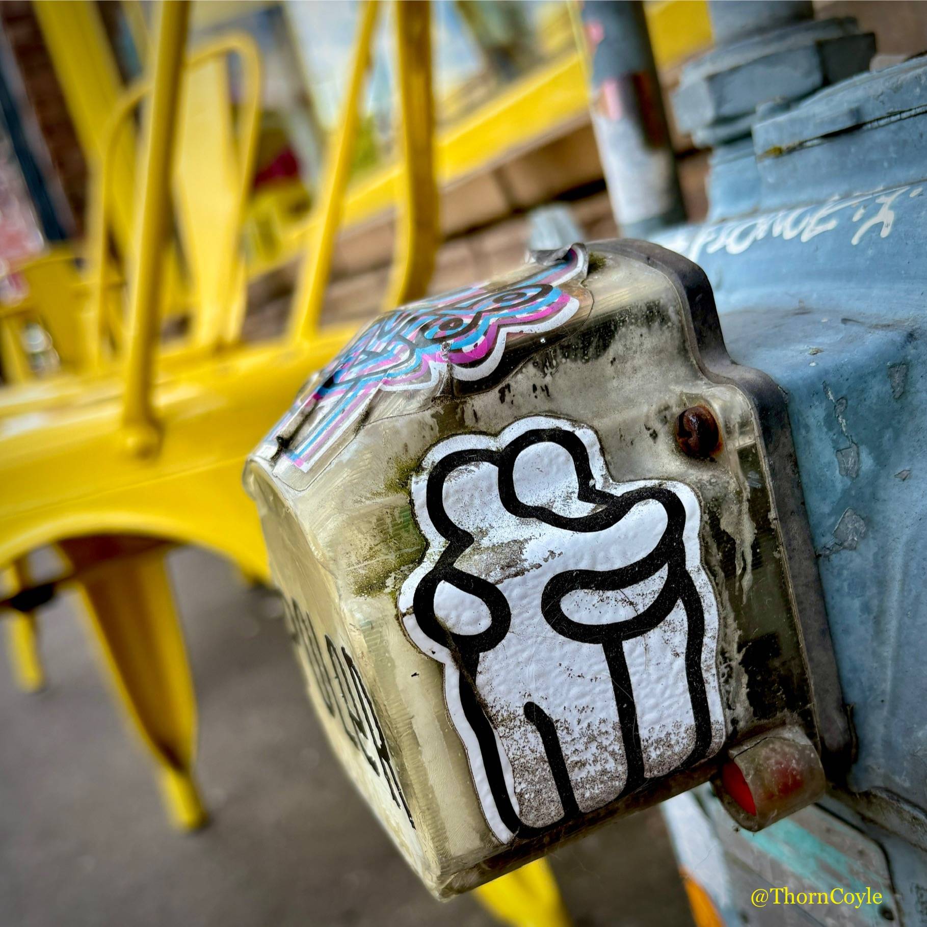city sidewalk, a sticker of two humans hugging