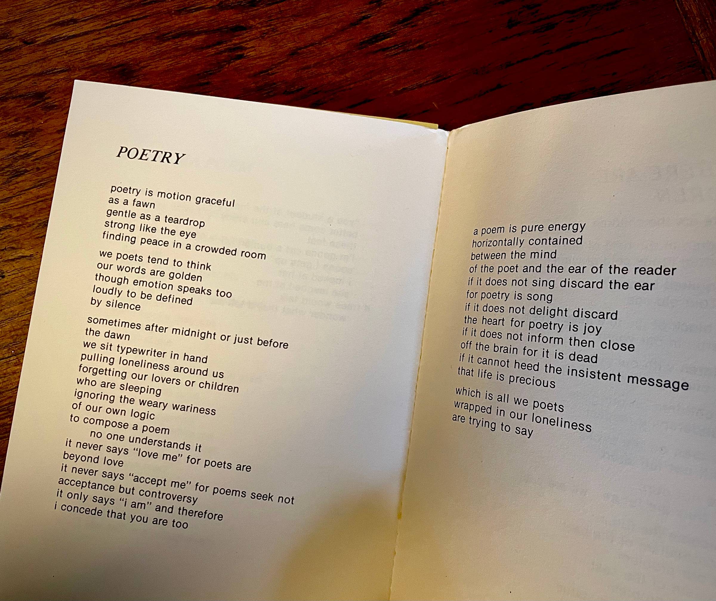 photo of an open book with a Nikki Giovanni poem:poetry is motion graceful as a fawn gentle as a teardrop strong like the eye finding peace in a crowded room we poets tend to think our words are golden though emotion speaks too loudly to be defined by silence sometimes after midnight or just before the dawn we sit typewriter in hand pulling loneliness around us forgetting our lovers or children who are sleeping ignoring the weary wariness of our own logic to compose a poem no one understands it it never says "love me" for poets are beyond love it never says "accept me" for poems seek not acceptance but controversy it only says "i am" and therefore i concede that you are too a poem is pure energy horizontally contained between the mind of the poet and the ear of the reader if it does not sing discard the ear for poetry is song if it does not delight discard the heart for poetry is joy if it does not inform then close off the brain for it is dead if it cannot heed the insistent message that life is precious   which is all we poets wrapped in our loneliness are trying to say