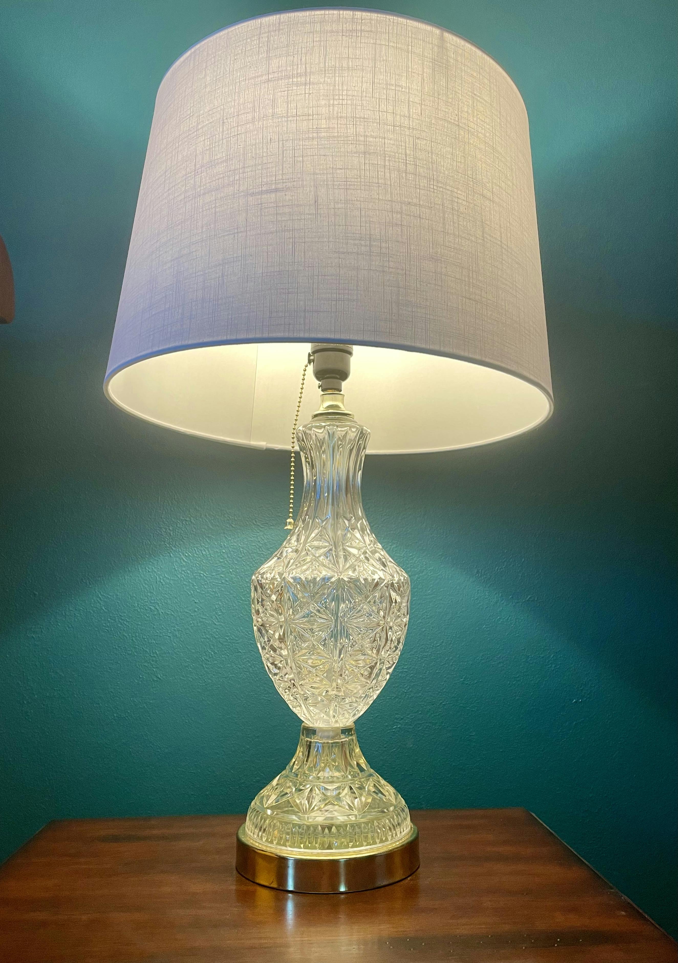 a cut crystal lamp base with a cloth lamp shade