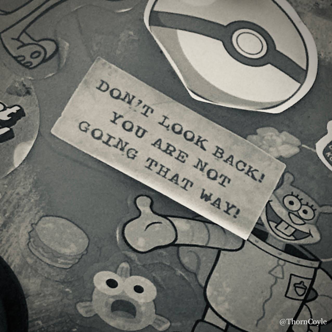 photo of a bunch of peeling stickers. One reads Don't Look Back! You Are Not Going That Way