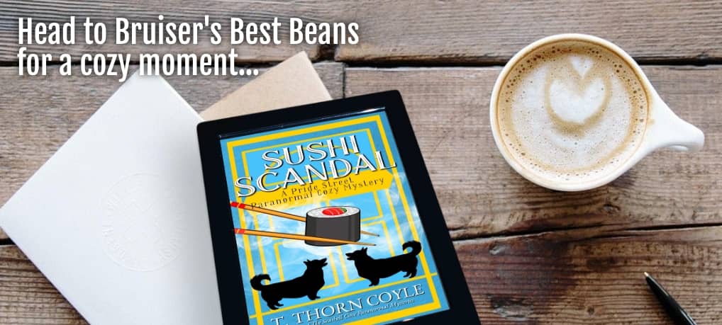 a wood table with a cappuccino, papers, and pen. plus the sushi scandal ebook. "Head to Bruiser's Best Beans for a cozy moment..."