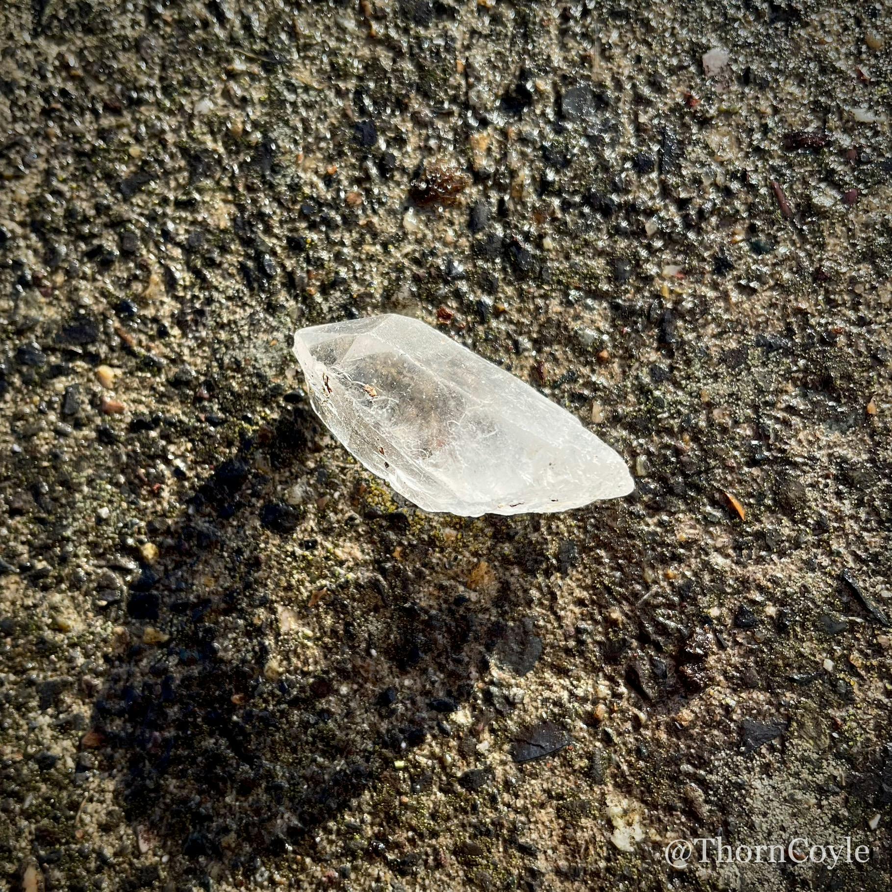 a crystal on a sidewalk in the sun