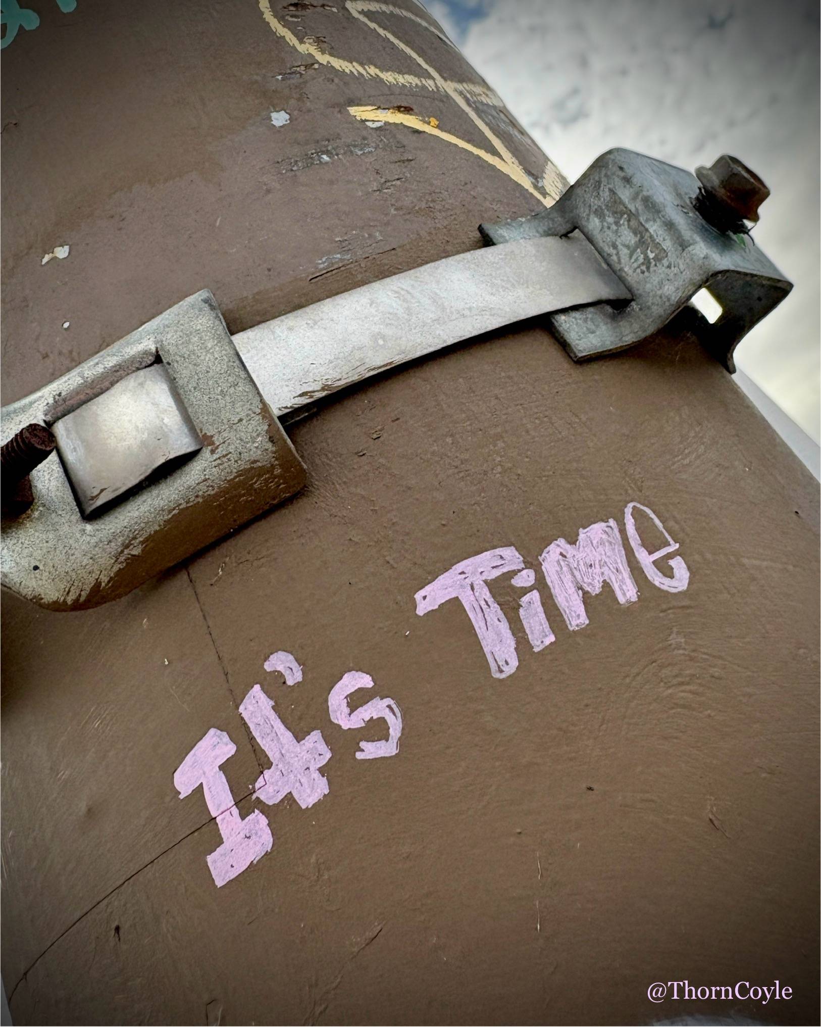 Photo: graffiti on a metal light pole reads: It's Time.