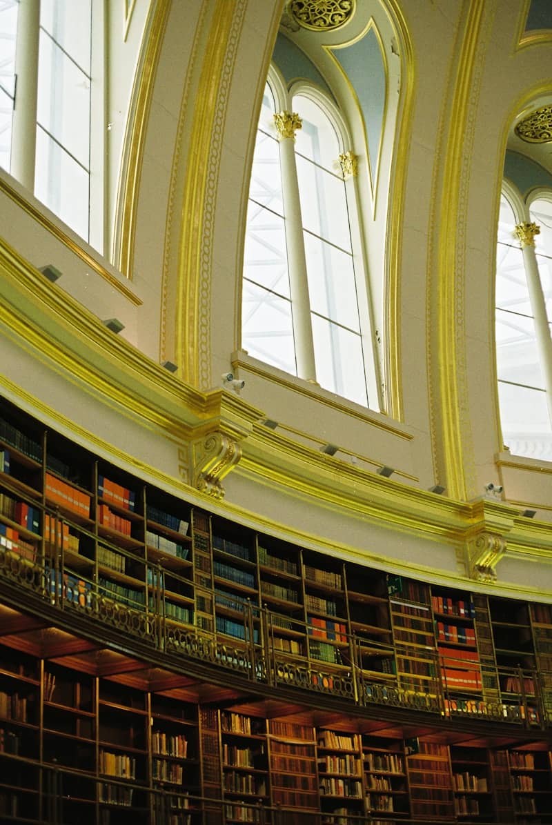 Grand library interior with curved bookshelves and arched windows.