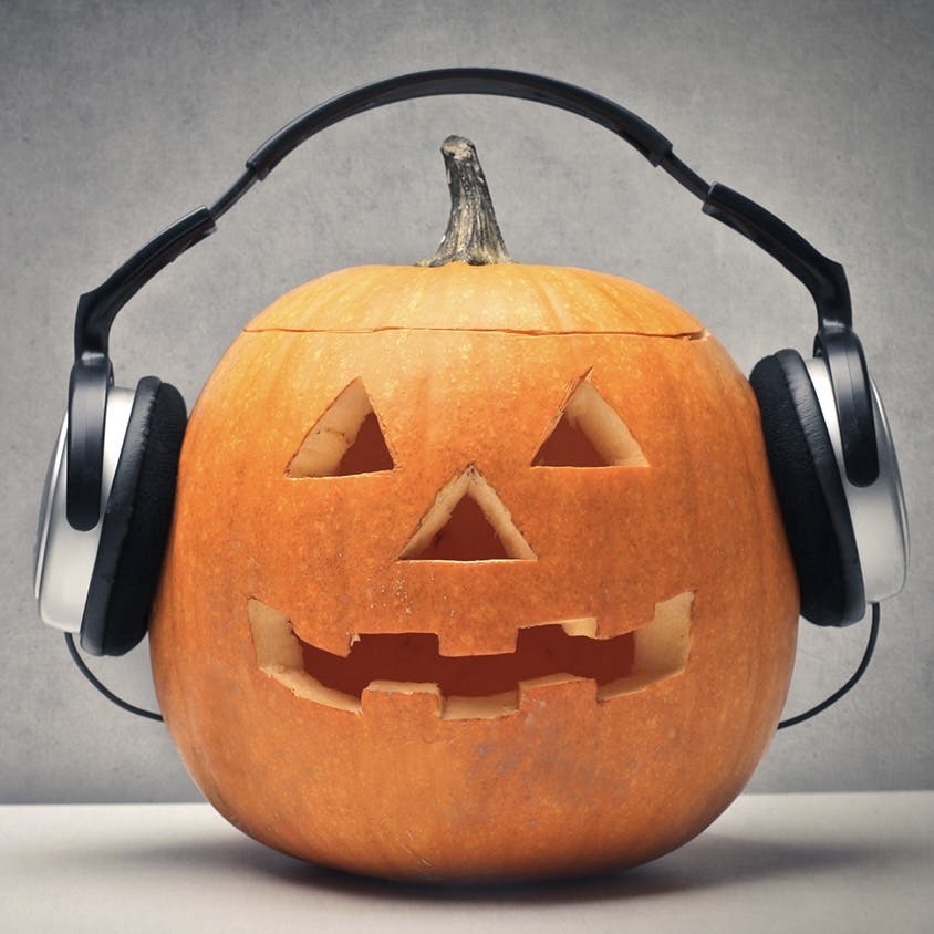 A jack-o’-lantern wearing headphones