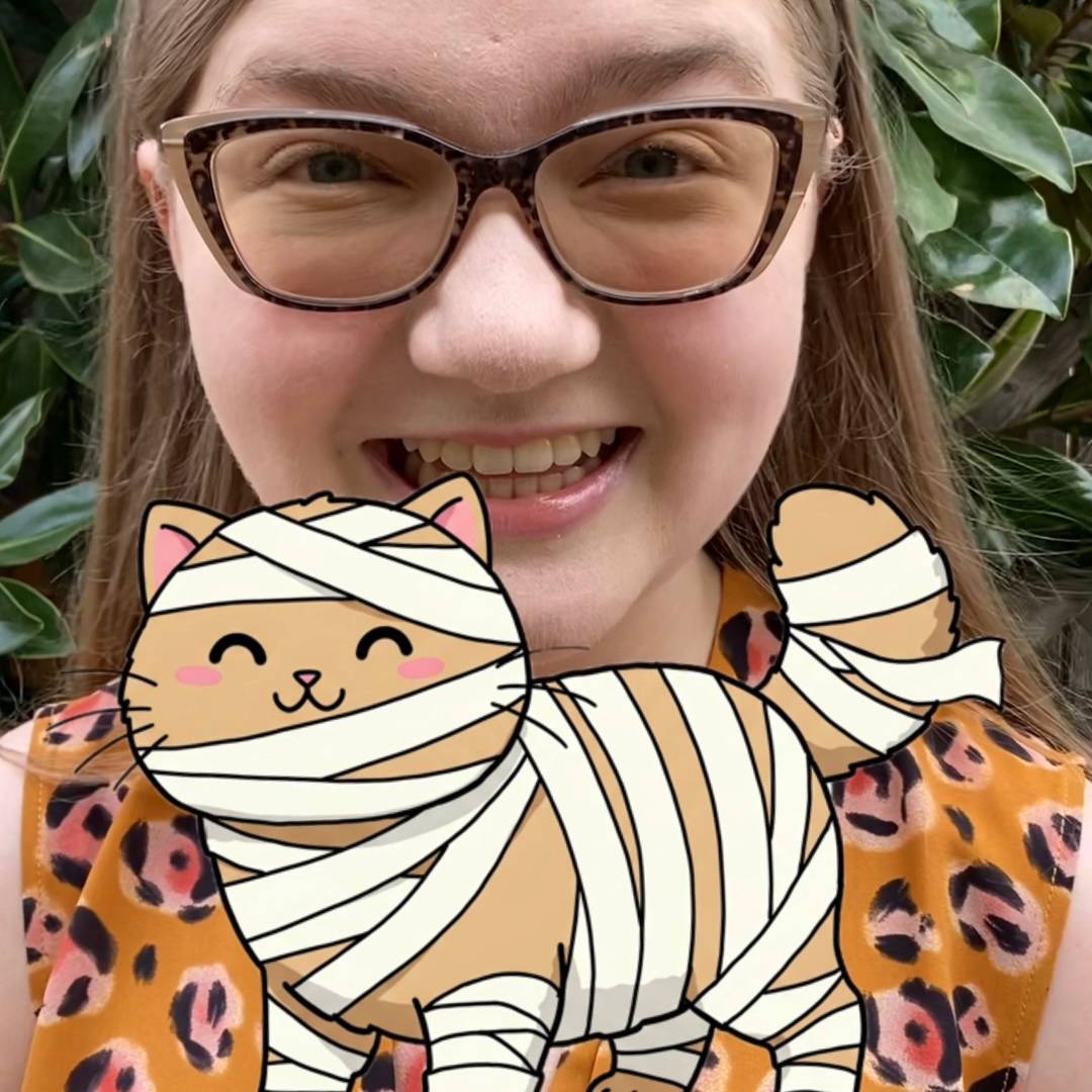 Madeline with a cat wearing a mummy costume