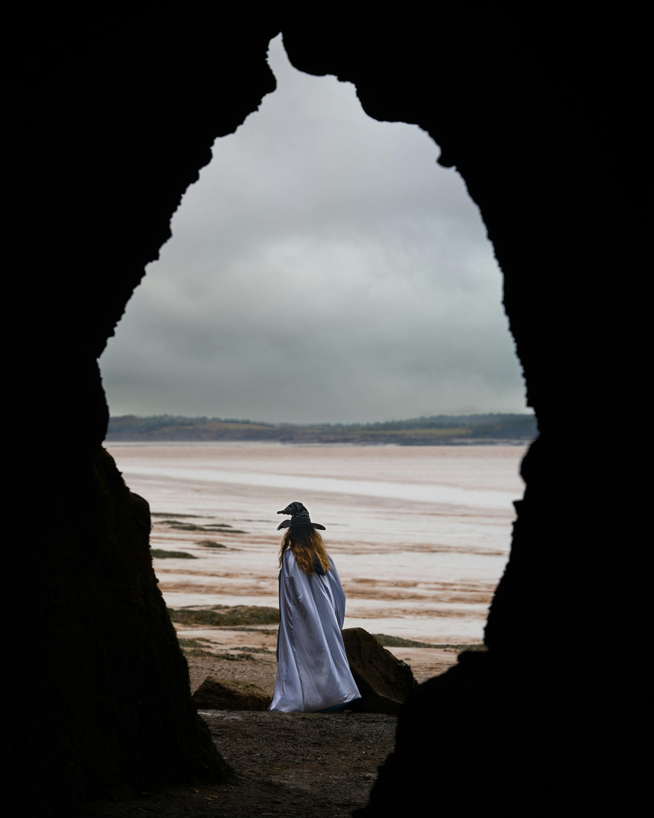 A witch at the ocean framed through rocks. 