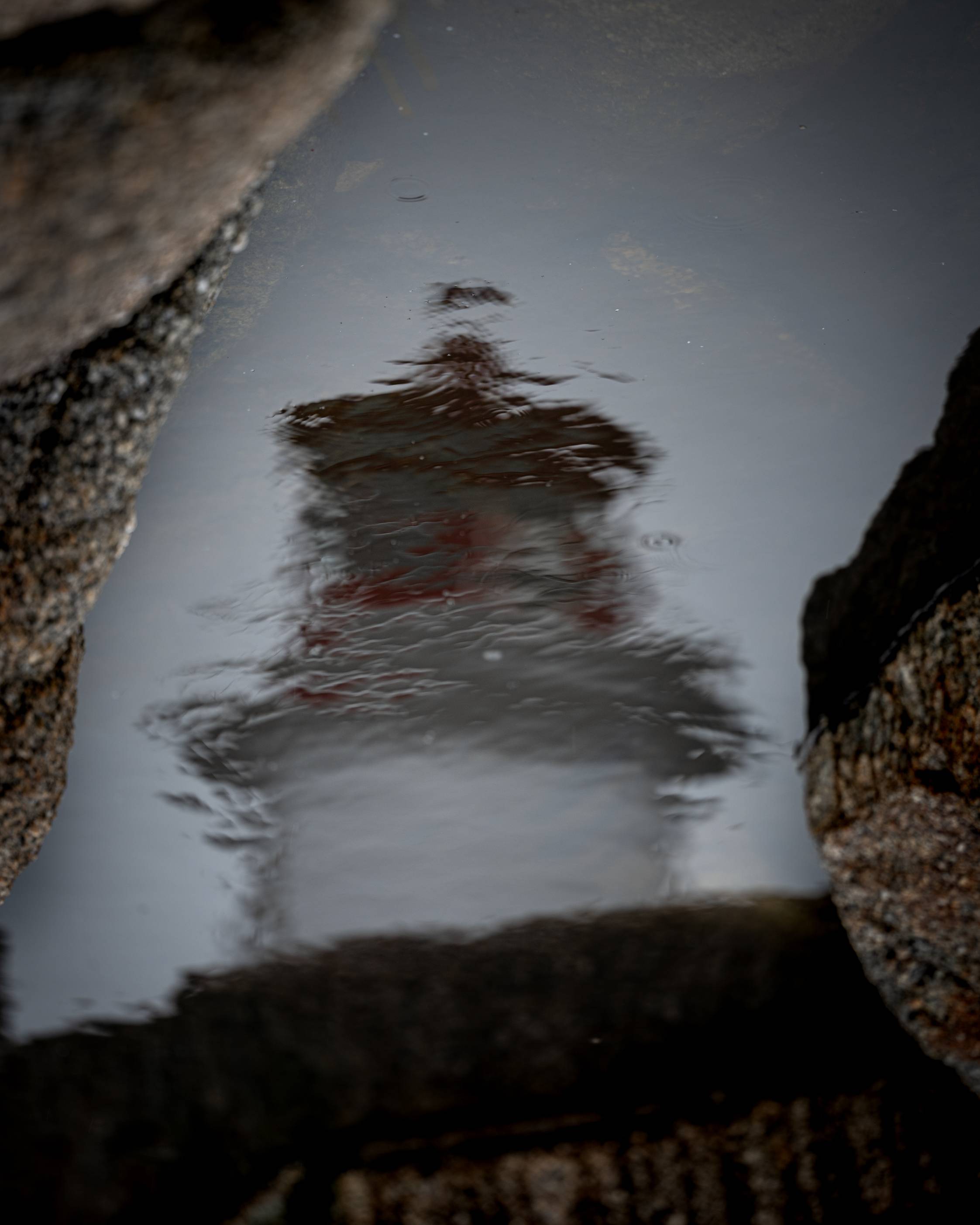 Peggy's Cove Lighthouse as reflected in the rippled water. 