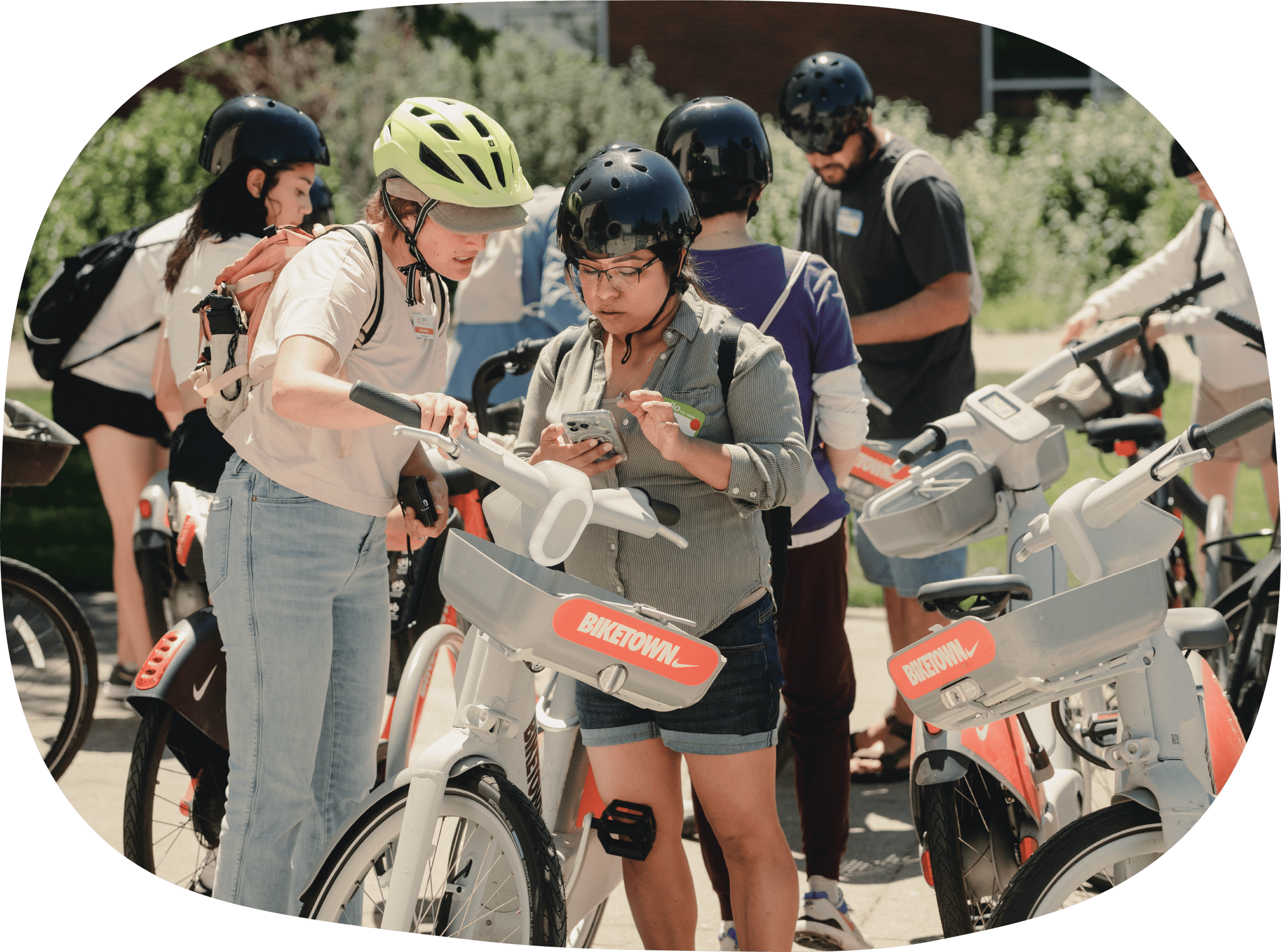 person showing someone phonescreen, surronded by BIKETOWN bikes 
