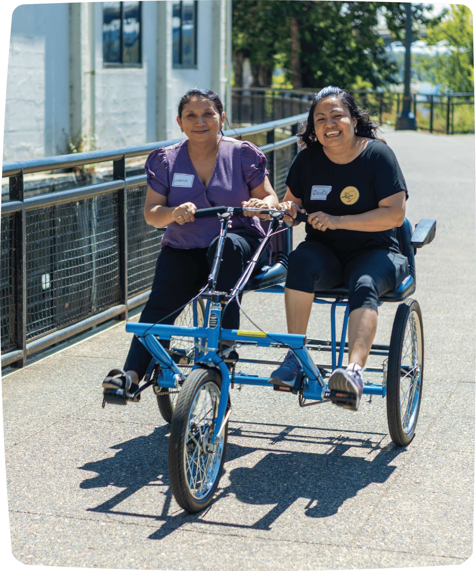 Two people are riding together on a two-person adaptive bike