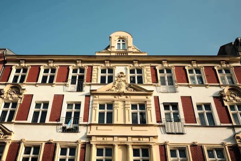 Ornate old building facade with many windows against blue sky.