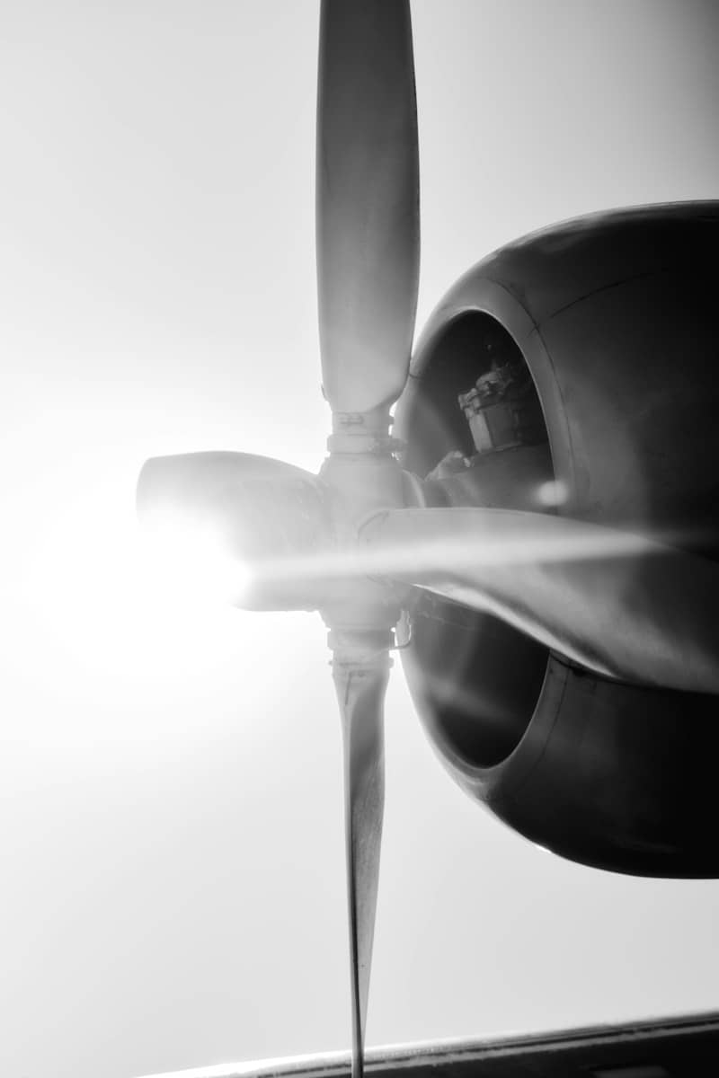 A black and white close-up of an airplane propeller backlit by bright light
