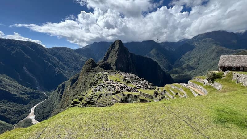 Ancient ruins on a mountainside under a cloudy sky