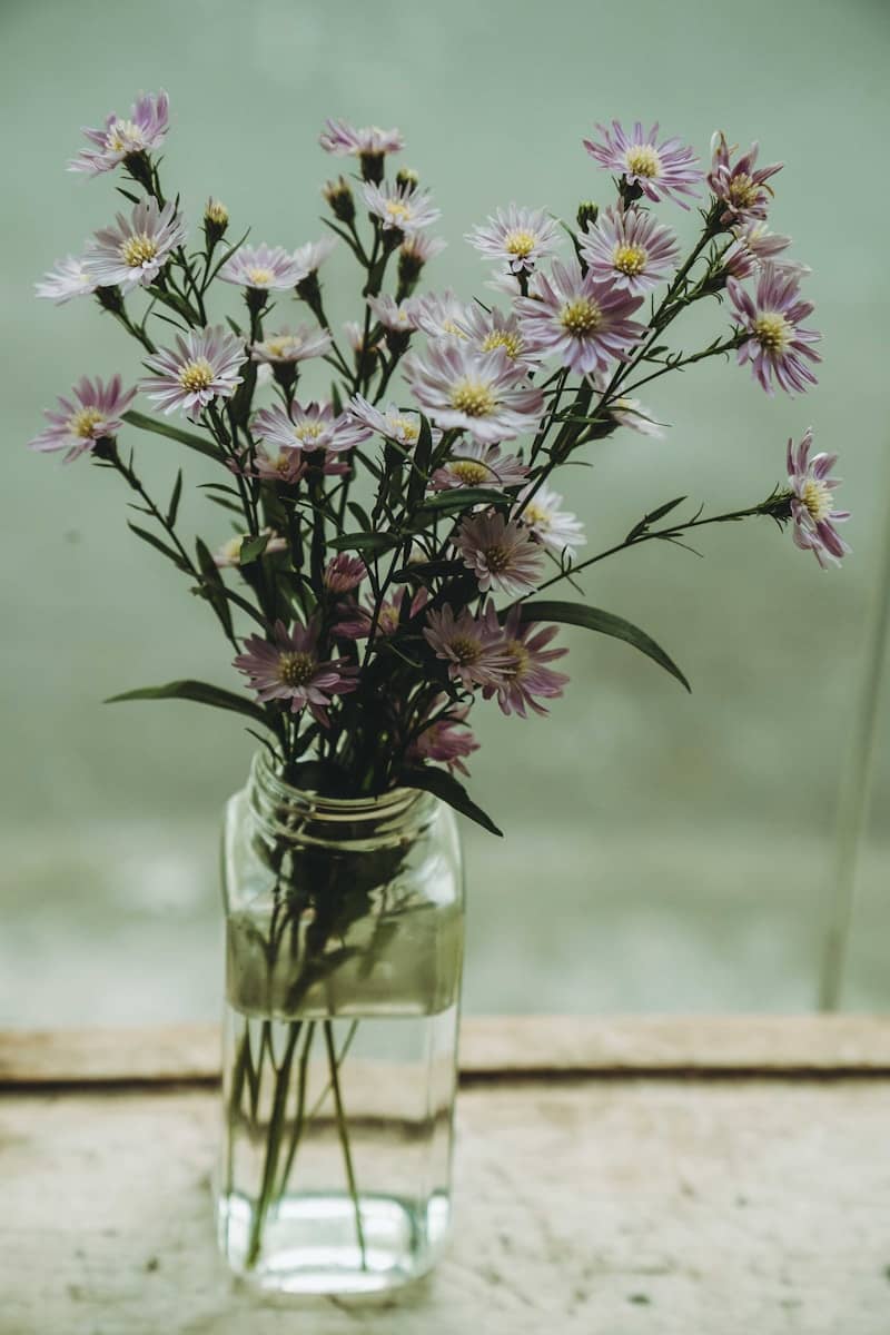 A vase filled with purple flowers sitting on top of a table