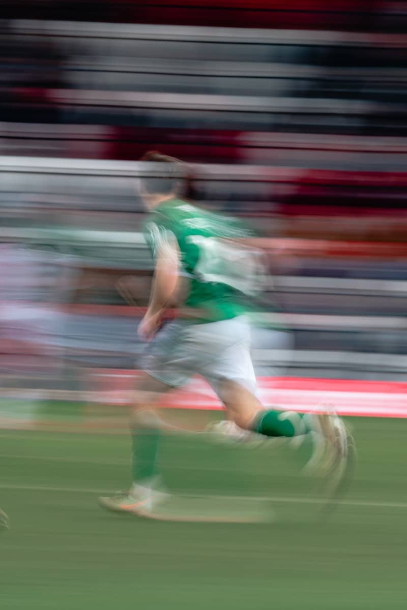 Soccer player in green running on field