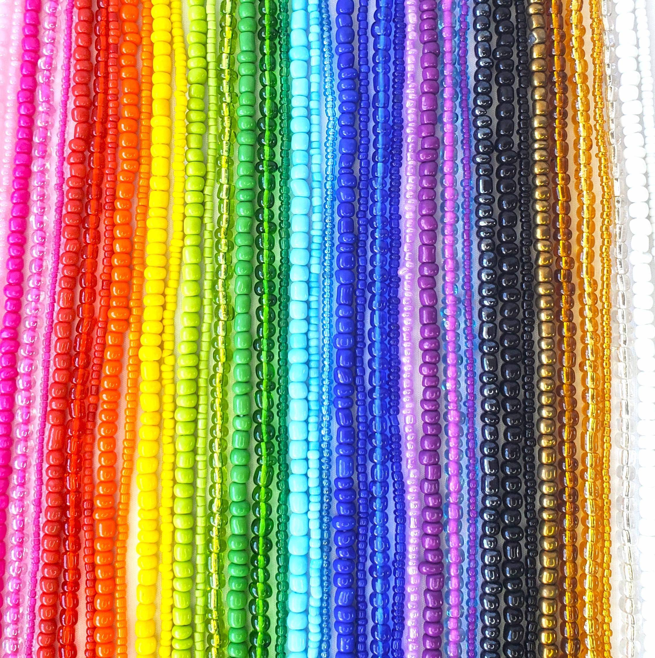 An assortment of colorful beads organized in vertical rows. The beads display a vibrant spectrum of colors, ranging from pink, red, orange, yellow, and green to blue, purple, black, and white. The beads have a glossy finish, adding a shiny texture to the image.