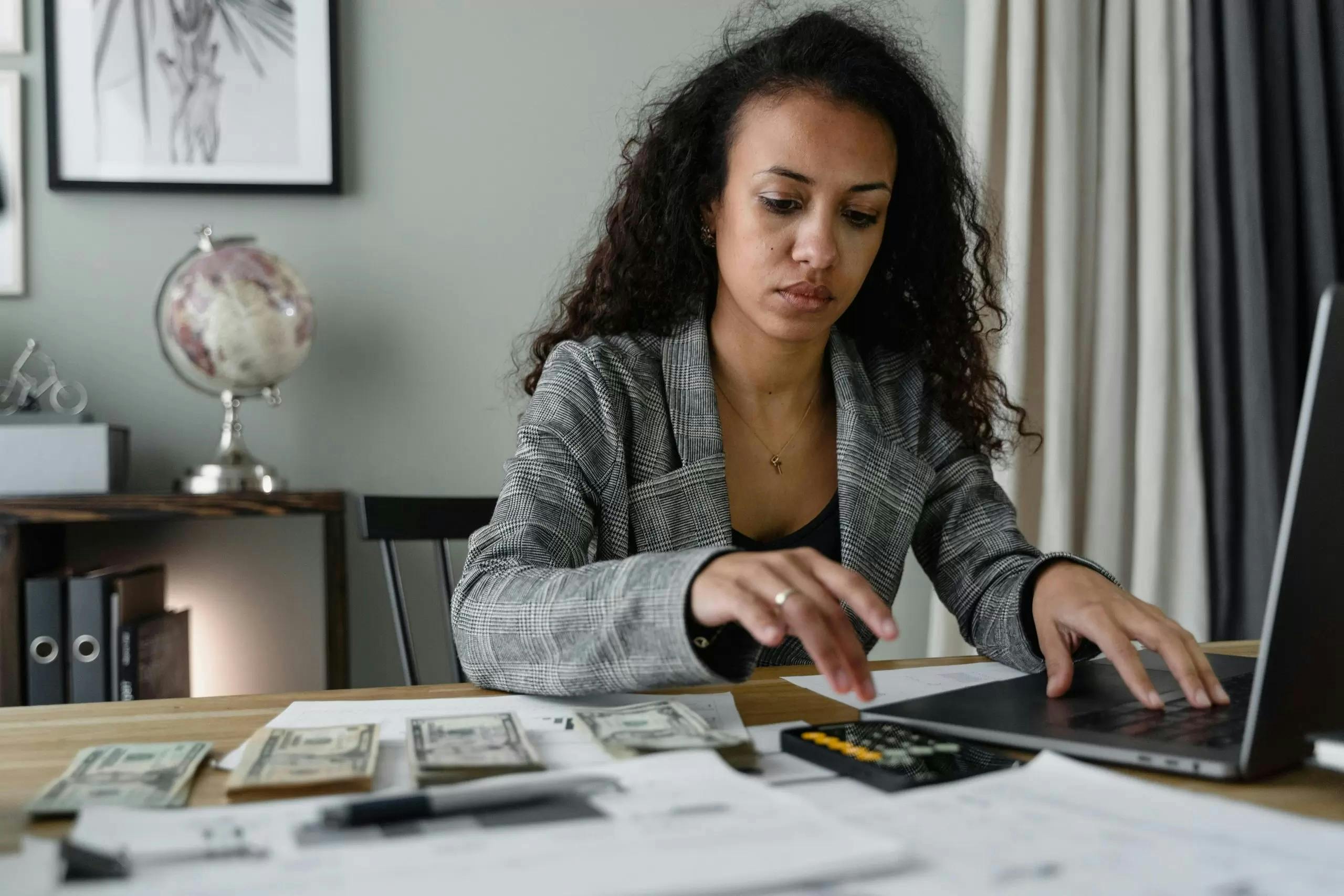 Stressed business woman of colour working an adding machine