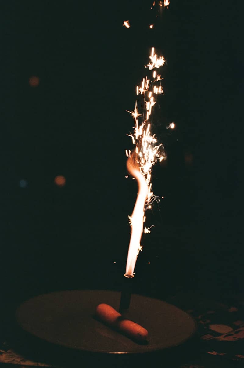 A cake with a sparkling candle at night