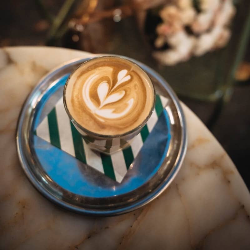 Latte art in a glass on a saucer