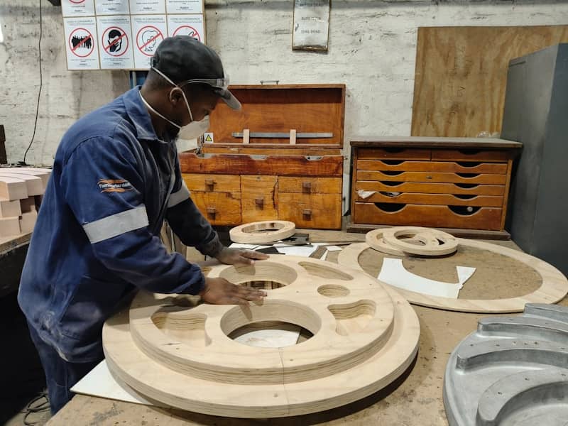 A worker examines wooden molds in a workshop.