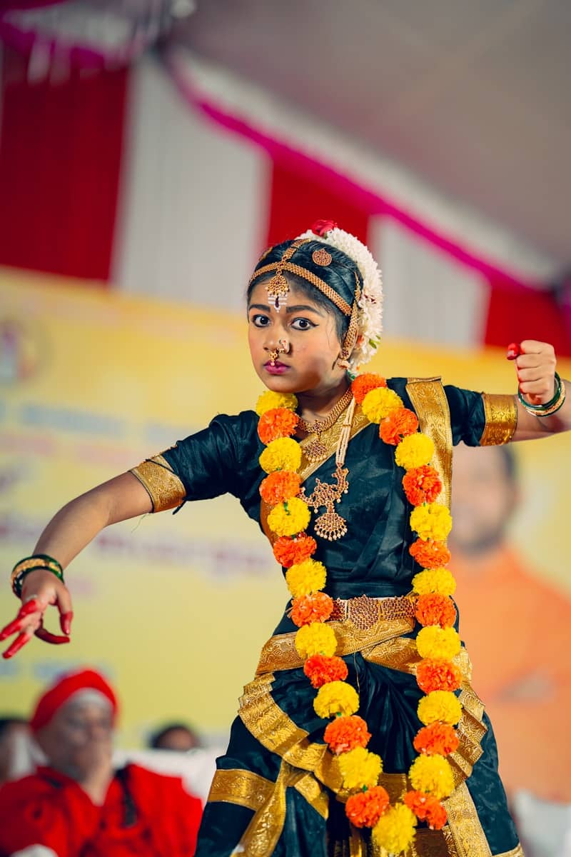 A young boy dressed in a traditional indian dance costume