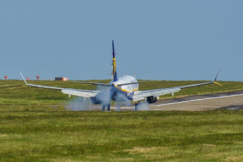 A plane is on the runway with smoke coming out of it