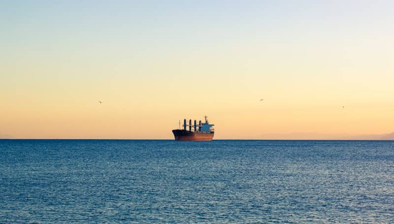 A large cargo ship sailing across a large body of water