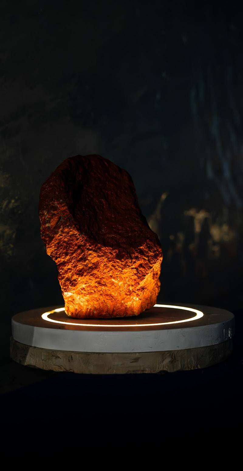 A stone is illuminated on a round pedestal.