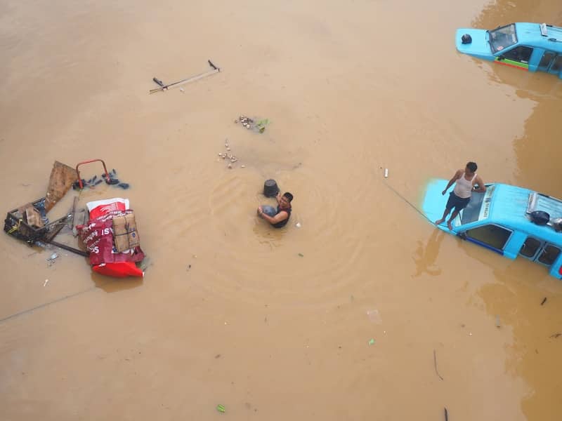 Flood waters trap people and vehicles.