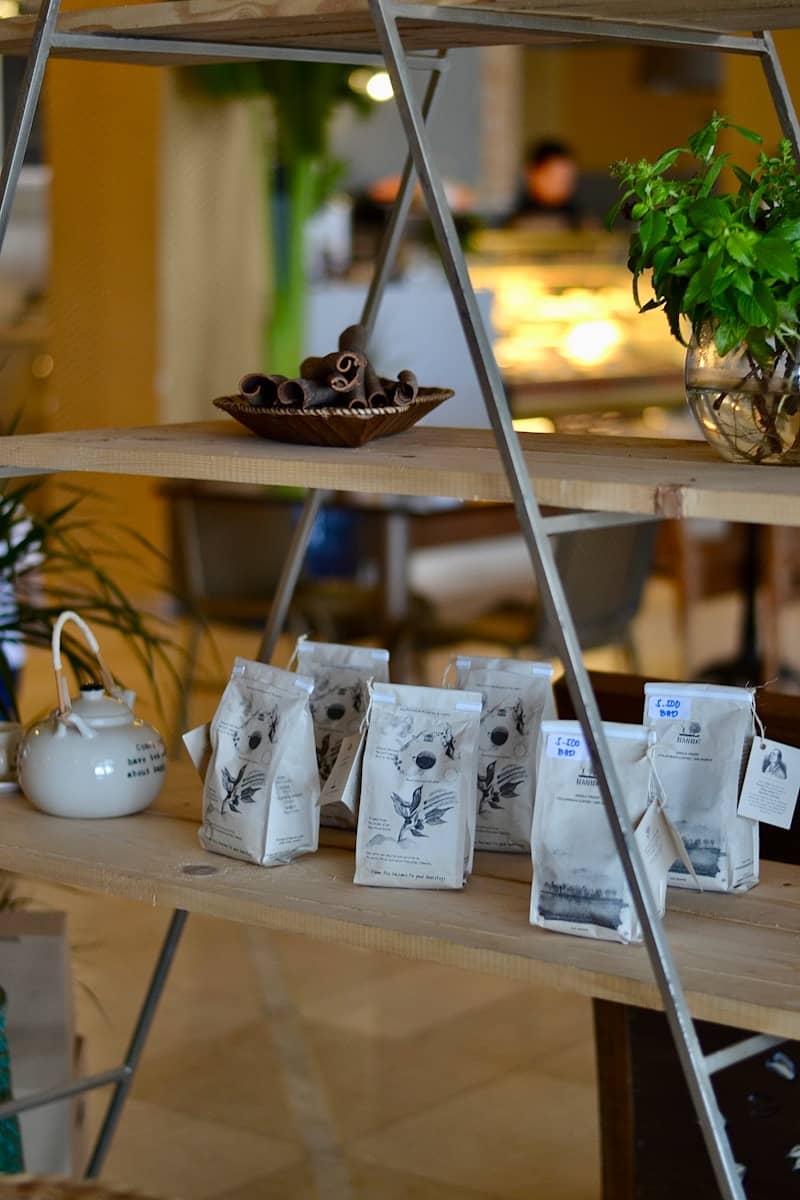 Shelves displaying tea, cinnamon rolls, and plants.